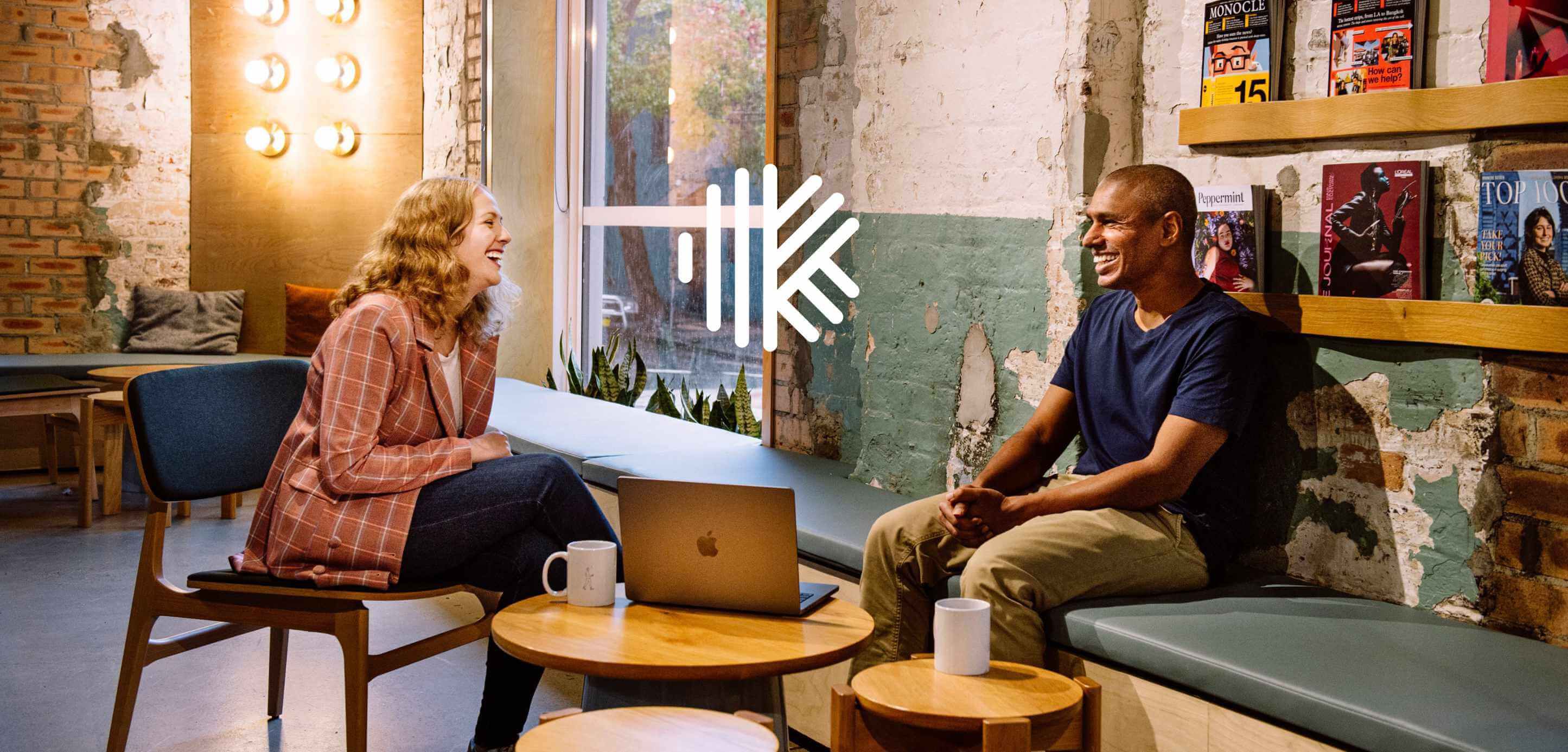 Two people sitting and talking in an office.